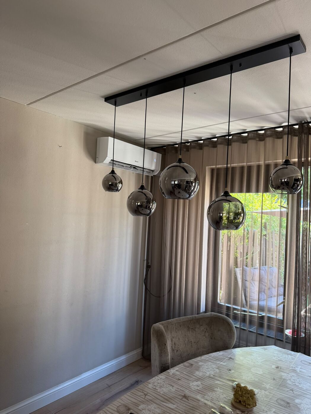 Airco binnenunit in een woonkamer naast de eettafel